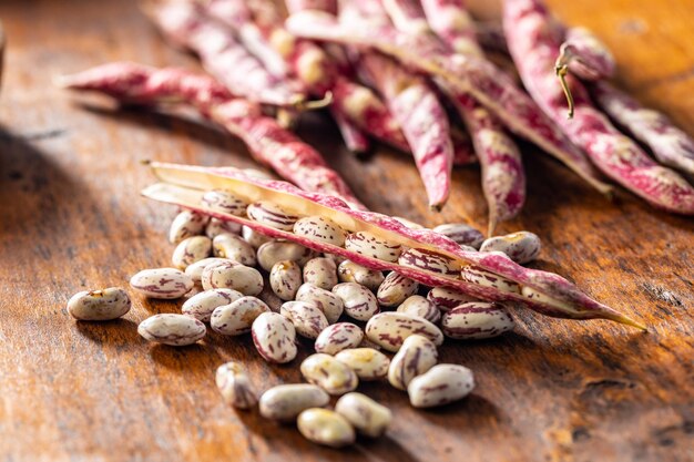 Cranberry beans Borlotti beans Beans pods on wooden table
