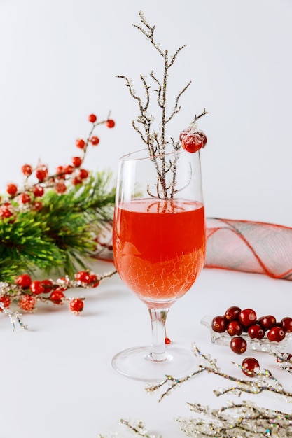 Cranberry beverage with fresh berries and christmas decoration on white background.