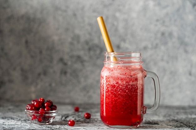 Cranberry and cowberry smoothie in mason jar with bamboo straw Refreshing summer fruit drink The concept of healthy eating Copy space
