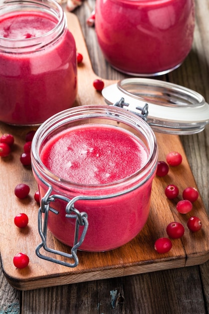 Cranberry curd in a glass jar on wooden table