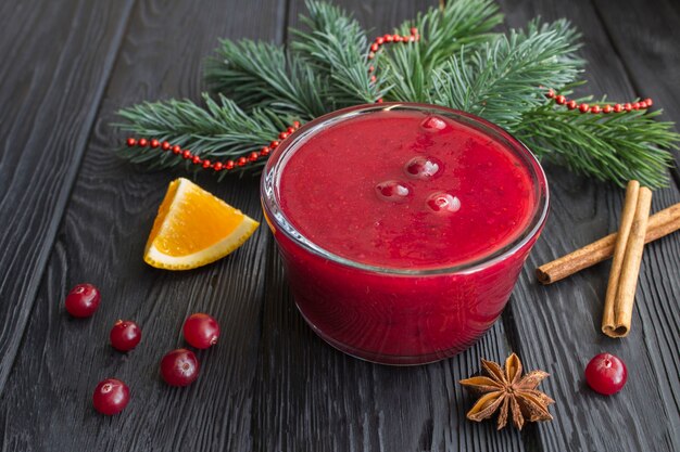 Cranberrysaus in de glazen kom op de zwarte houten tafel