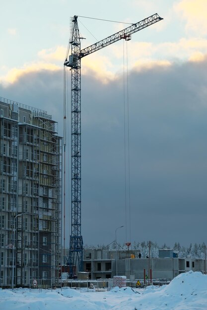 写真 クレーンと未完成の家 冬の建築工事