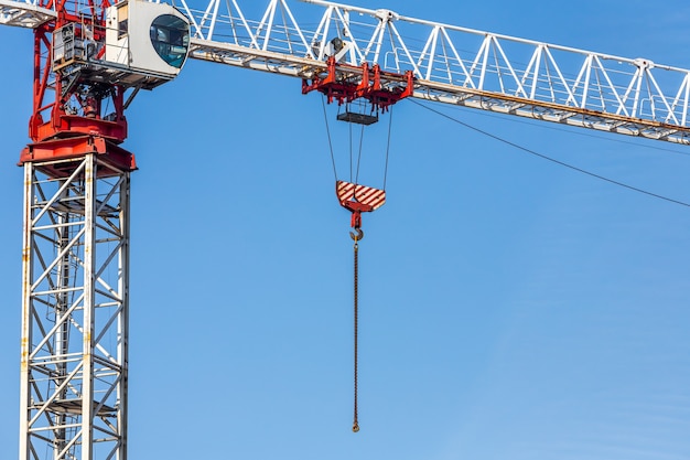 Crane and building under construction against blue sky. Construction site.