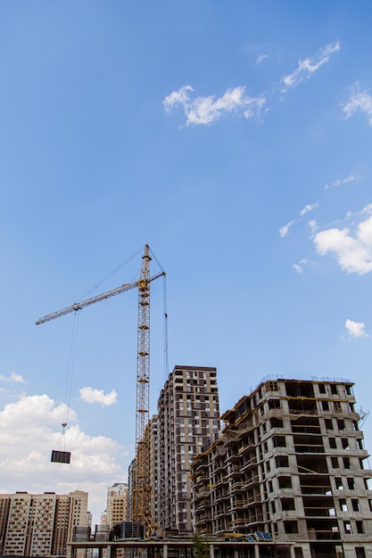 Gru e edificio in costruzione contro il cielo blu