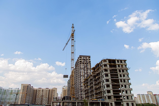 Crane and building under construction against blue sky