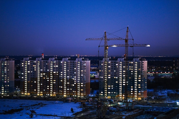 Crane and building under construction against blue sky