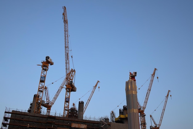 Crane and building under construction against blue sky