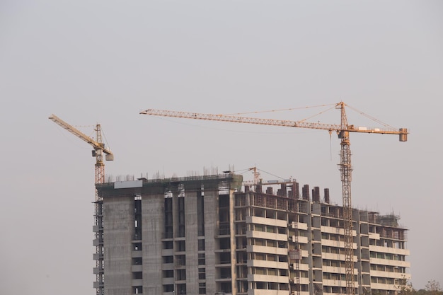 Crane by building against clear sky