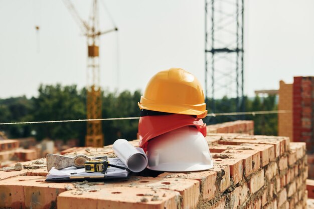 Crane is far away Close up view of protective hard hats that laying down on the bricks