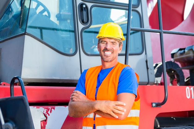 Crane operator standing proud on company yard