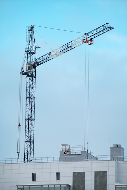 クレーンと未完成の家建物の建設クレーンは家の細部を引っ張っています