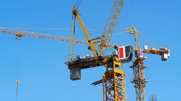 Crane working on construction site and heavy steel material and yellow color and blue sky