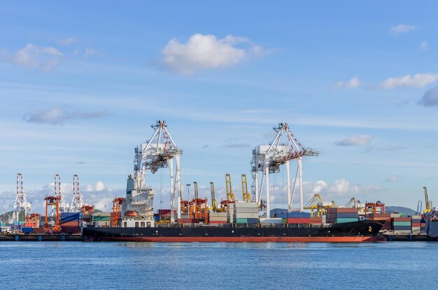 Photo cranes at commercial dock against sky cargo port station