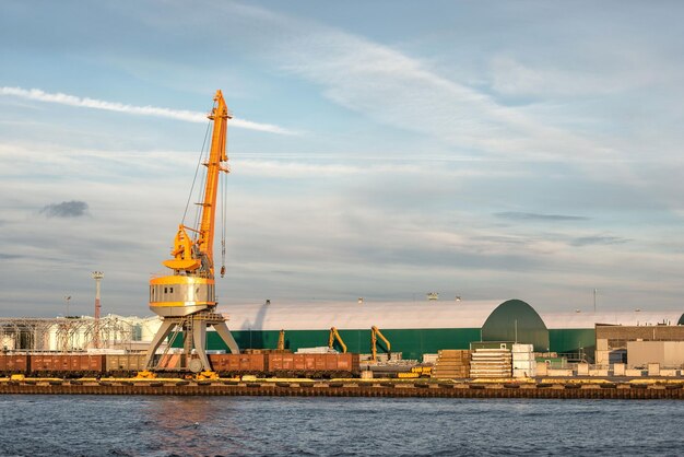 Cranes at commercial dock against sky