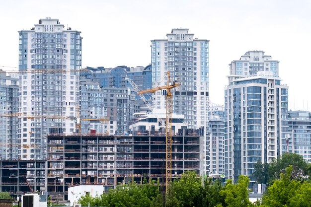 Cranes on a construction site of building of modern residential district High apartment buildings or skyscrapers in a new elite complex.