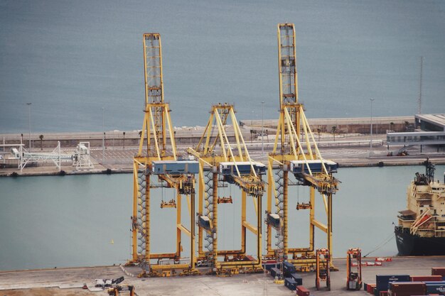 Photo cranes at construction site at harbor against sky