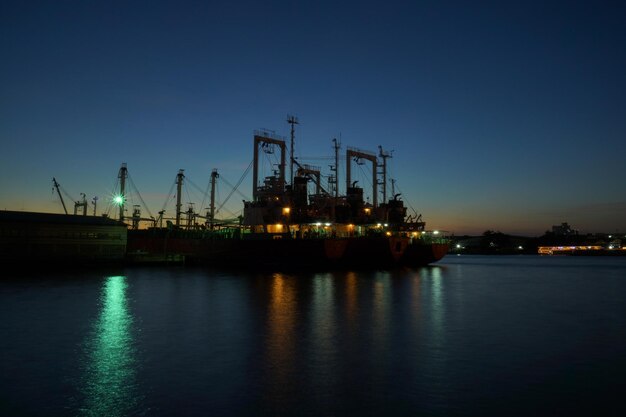 Photo cranes at harbor against clear sky at dusk