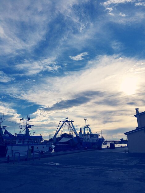 Photo cranes at harbor against sky in city