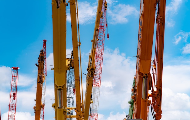 Gru cingolata contro il cielo blu e nuvole bianche industria immobiliare gru cingolata rossa