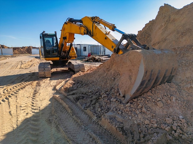 crawler excavator machine unloading sand or soil at construction area background closeup of a powerful excavator rental of construction equipment earthworks contractor