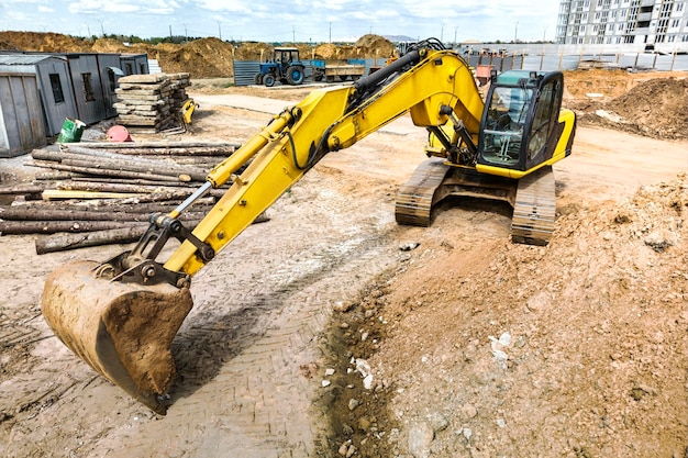 Photo crawler excavator machine unloading sand or soil at construction area background closeup of a powerful excavator rental of construction equipment earthworks contractor