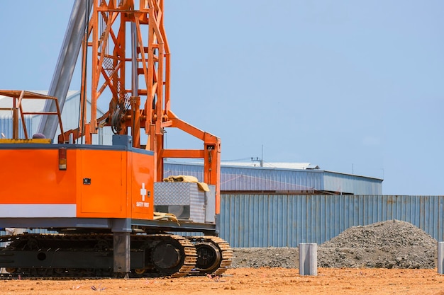 Crawler pile driver machine with concrete piling in construction site