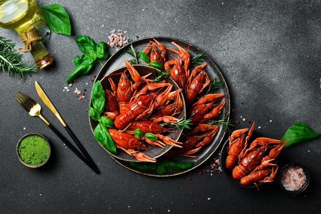 Crayfish Red boiled crawfishes in a bowl with rosemary and spices On a dark background Free space for the recipe