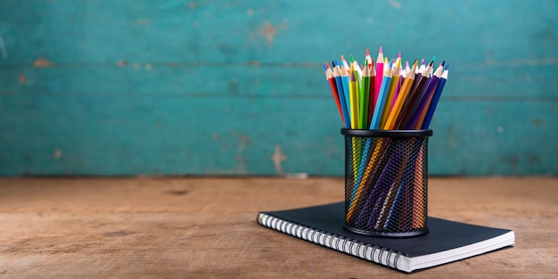 crayons and notebook on desk