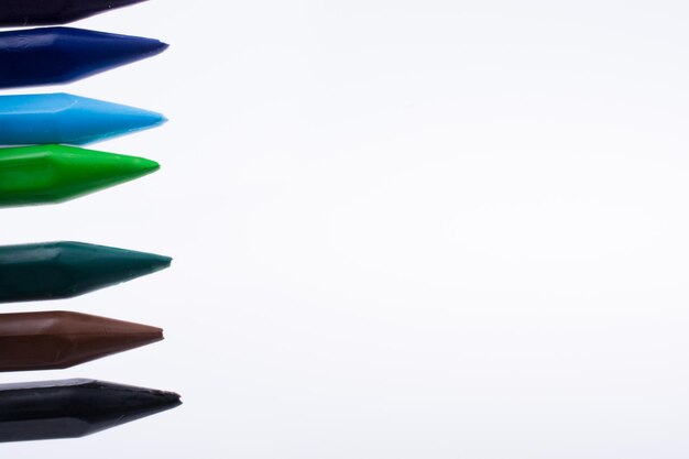 Crayons of various color on white background