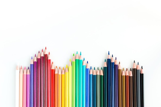 Crayons and watercolor pastels lined up isolated on white background