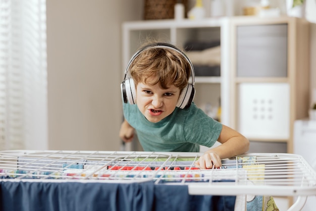 집안일을 하는 미친 소년은 아이에게 무선 헤드폰을 들으며 장난을 친다