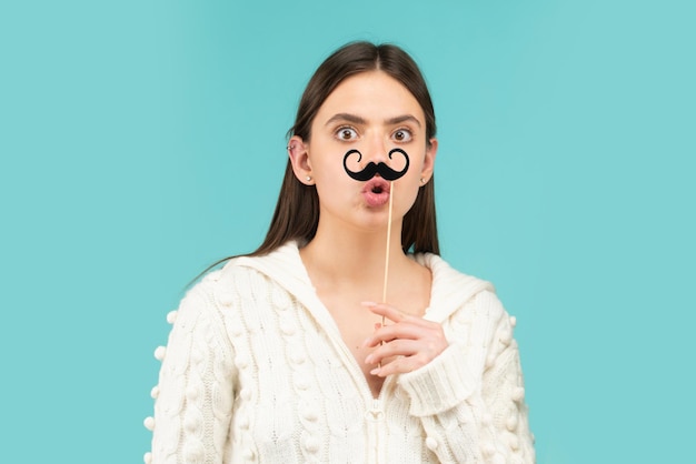 Crazy emotions. Just having fun. Woman holding fake mustache on her face. Suprised girl with moustache on stick.