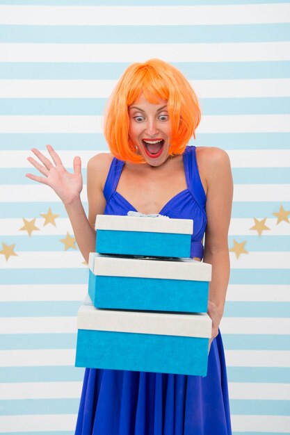 Crazy girl with present boxes. Happy girl chooses which box to open first. Happy with surprise. She is crazy about presents.