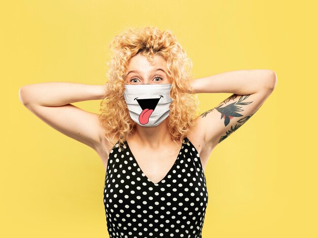 Photo crazy happy. portrait of young caucasian woman with emotion on her protective face mask isolated on studio background. beautiful female model. human emotions, facial expression, sales, ad concept.