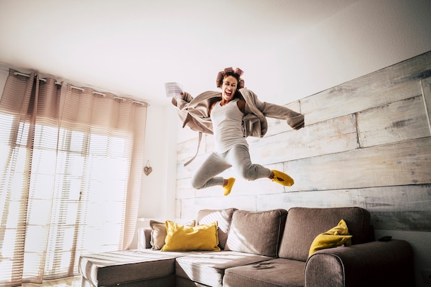 Crazy housewife alone woman jump on the sofa for happiness and success related news 