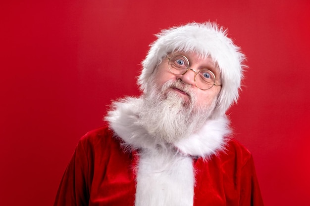 Crazy santa claus funny face isolated on red studio background fulfillment of desires