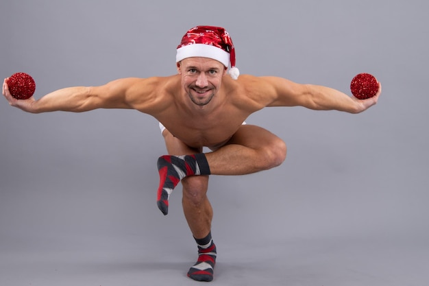 Crazy santa Naked gay santa in santa head funny yaga posing on gray studio background