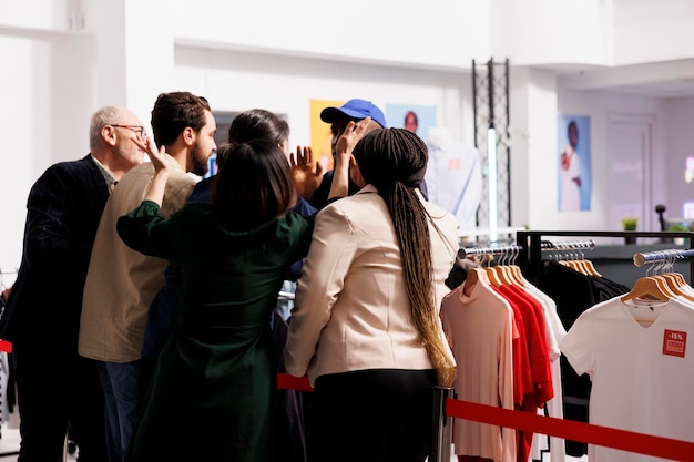 Сумасшедшие покупатели спорят и ведут себя грубо по отношению к полиции или офицеру безопасности, ожидая распродажи в "Черную пятницу" в магазине моды.