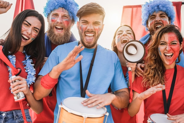 Foto appassionati di sport pazzi che suonano la batteria e urlano mentre sostengono la loro squadra