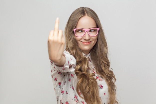 Crazy and stupid woman, showing fuck sign and smiling. Indoor shot