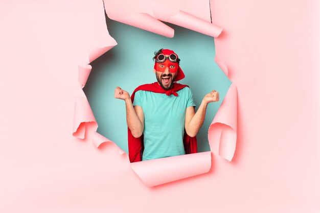 Crazy  super hero man celebrating a triumph like a winner in paper hole