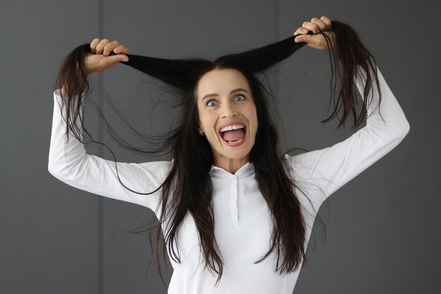 La donna pazza tiene i capelli e fa smorfie sbalzi d'umore nelle donne