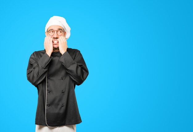 Crazy young chef making a nervous gesture