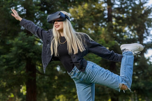 Crazy young lady wearing VR set and raising her leg and hand