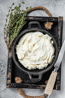 Crema di mascarpone in vassoio di legno per tiramisù. sfondo bianco. vista dall'alto.
