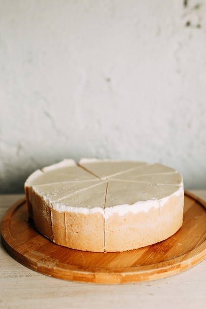 木の板にチーズケーキをクリーム状にします。短い生地でケーキをスライスします。