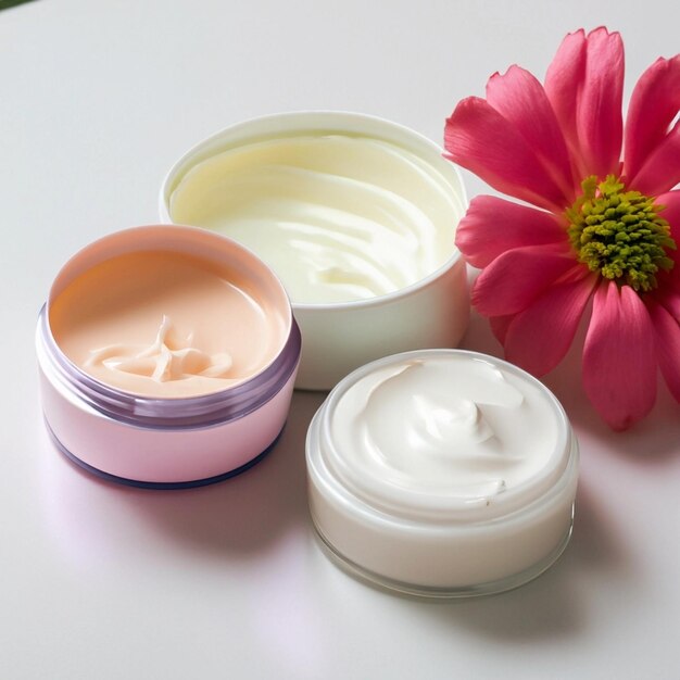 cream cosmetic products colored creams and a flower on a white table