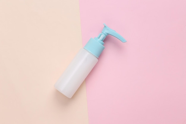 Cream dispenser fles op roze beige achtergrond