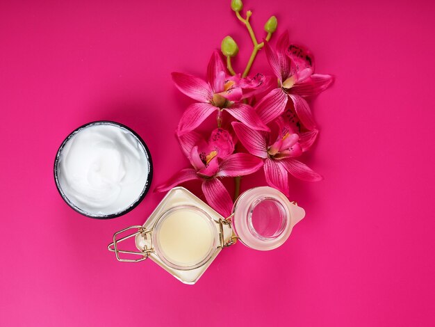 Foto barattolo di crema sul tavolo rosa con spazio per testo, bellezza e tema salute