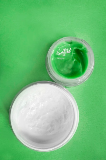 Cream jars on green background